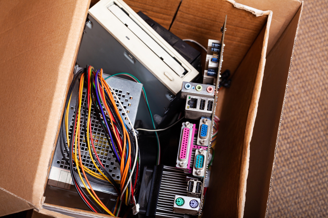 Electronic waste, cardboard box package full of e-waste, old dated desktop pc, computer components. Outdated technology safe disposal, throwing away obsolete electronic parts, eco recycling concept